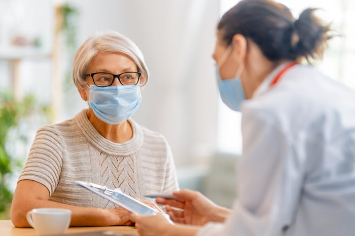 Doctora-y-señora-usando-máscaras-en-consulta-medica